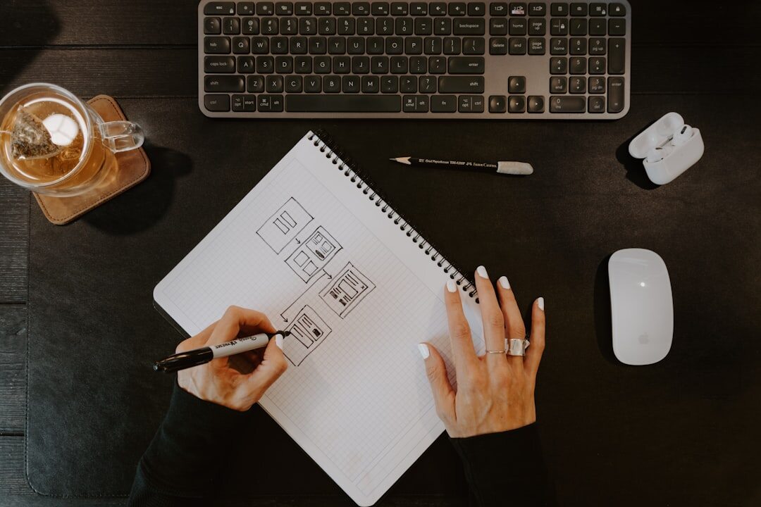 person writing in notebook at desk